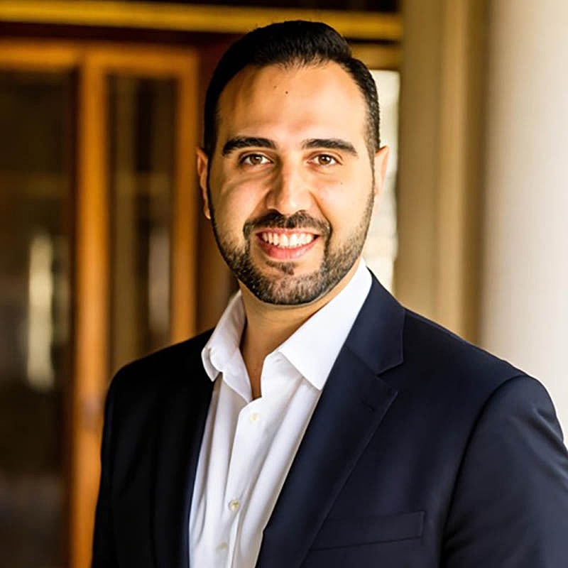 Smiling man in suit posing indoors.