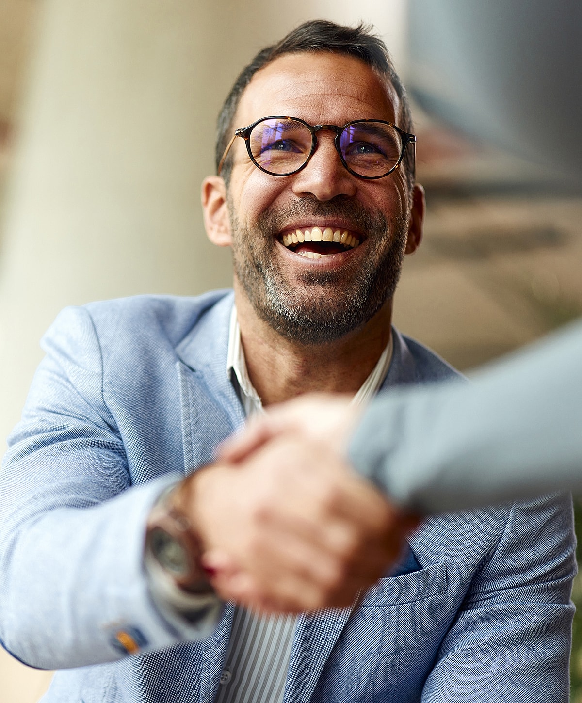 Smiling doctor in scrubs with arms crossed.