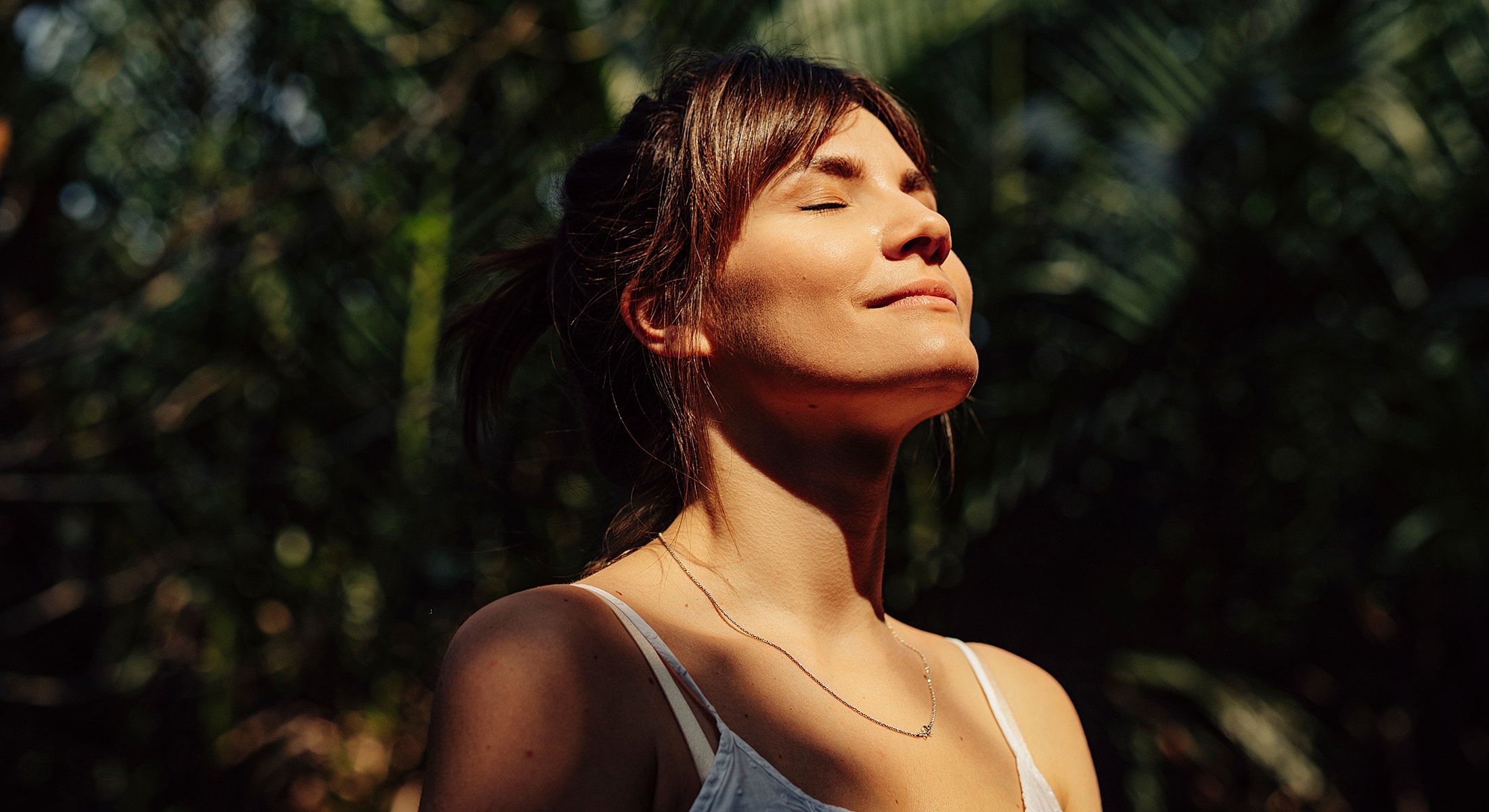 Doctor examining older woman's neck in clinic.