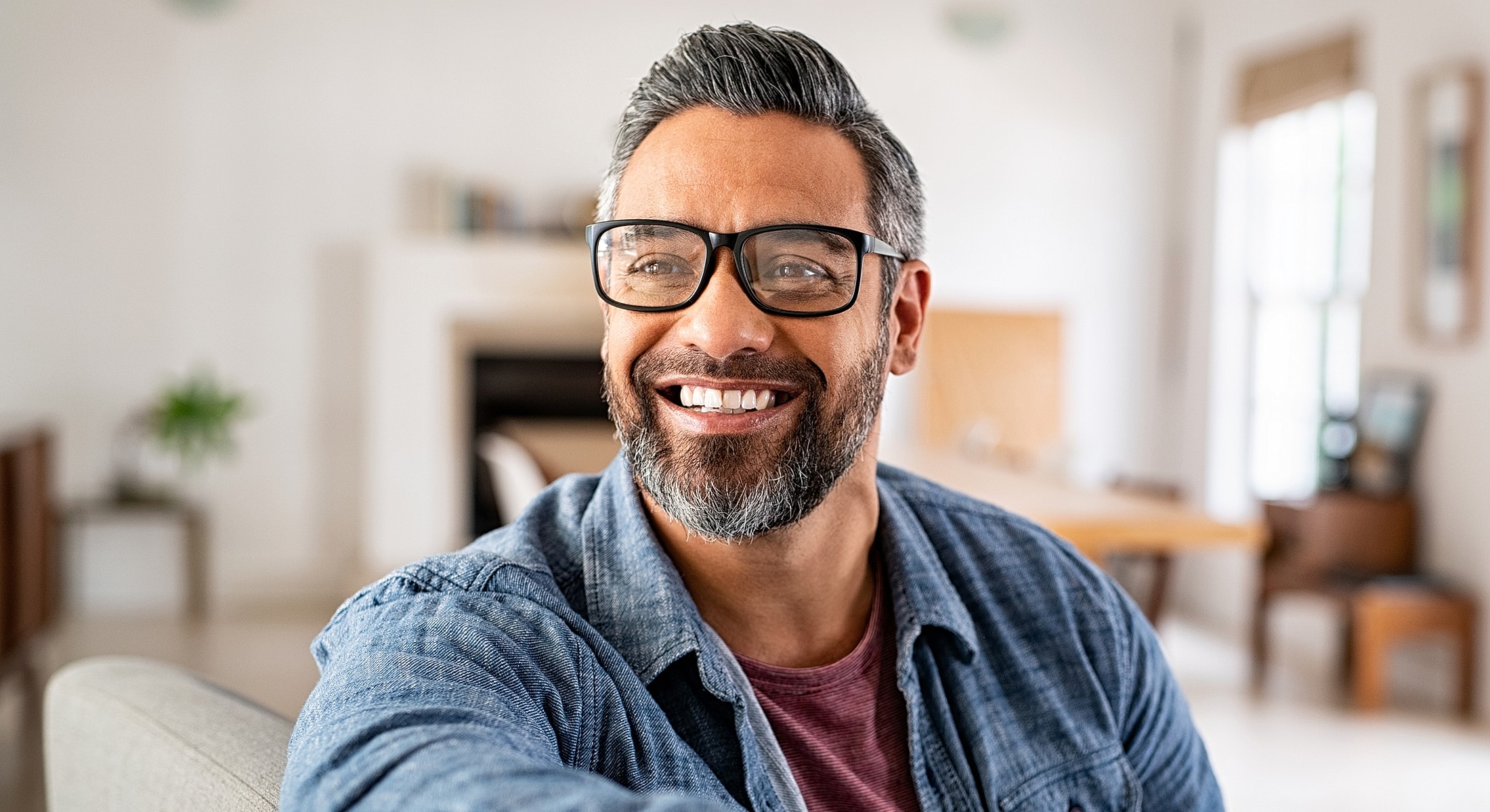 Smiling man with glasses in a cozy setting