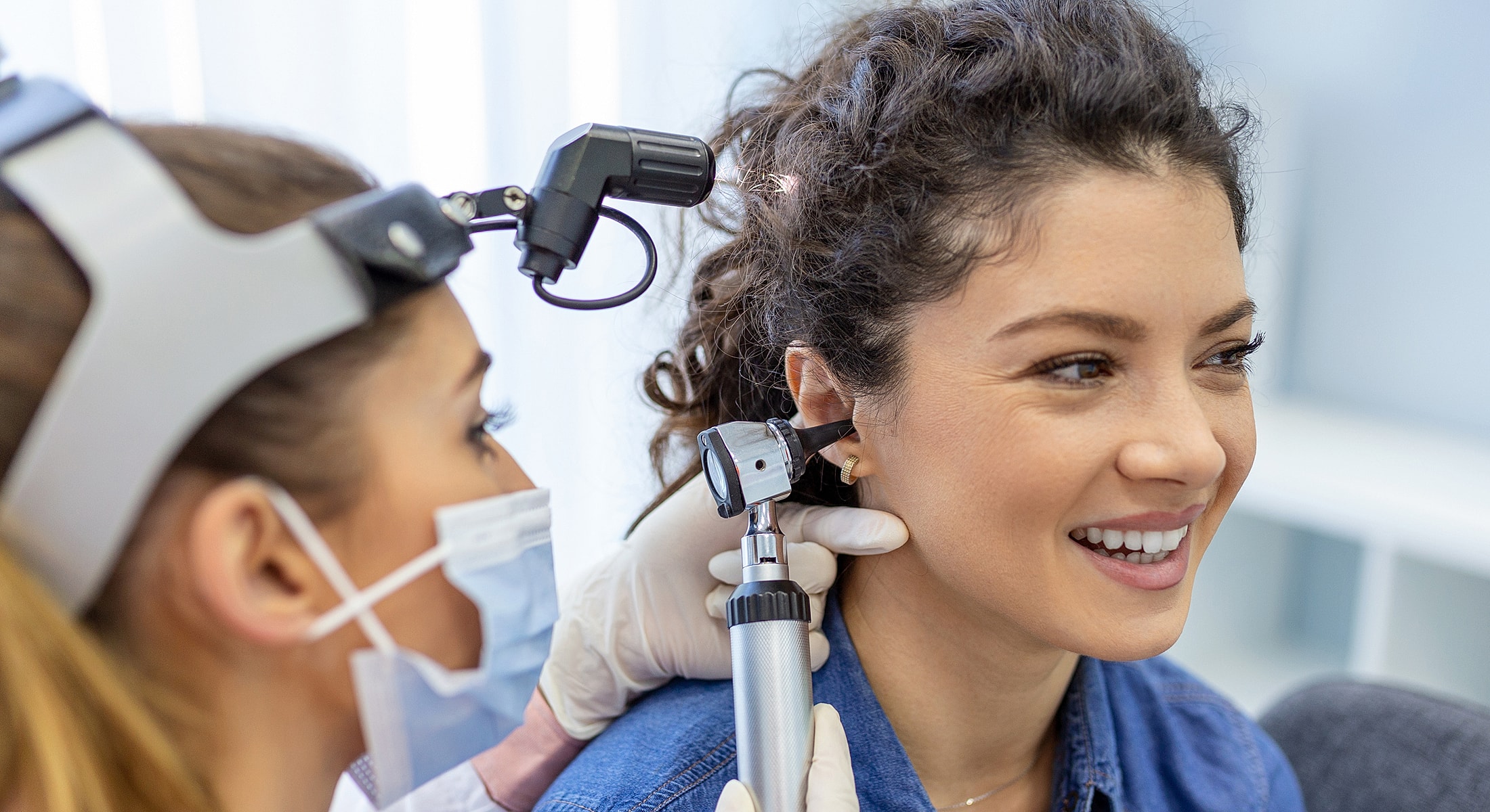 Patient receiving ear examination at doctor's office.