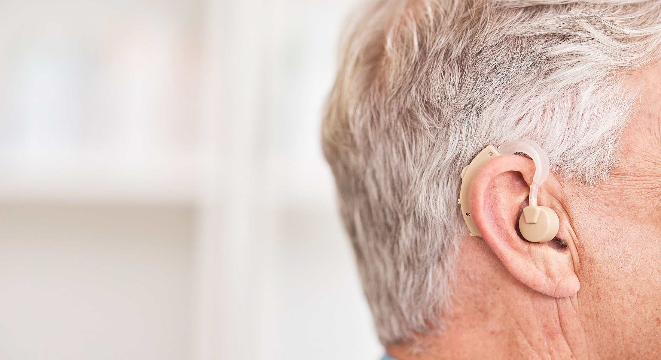 Person wearing a hearing aid in ear.