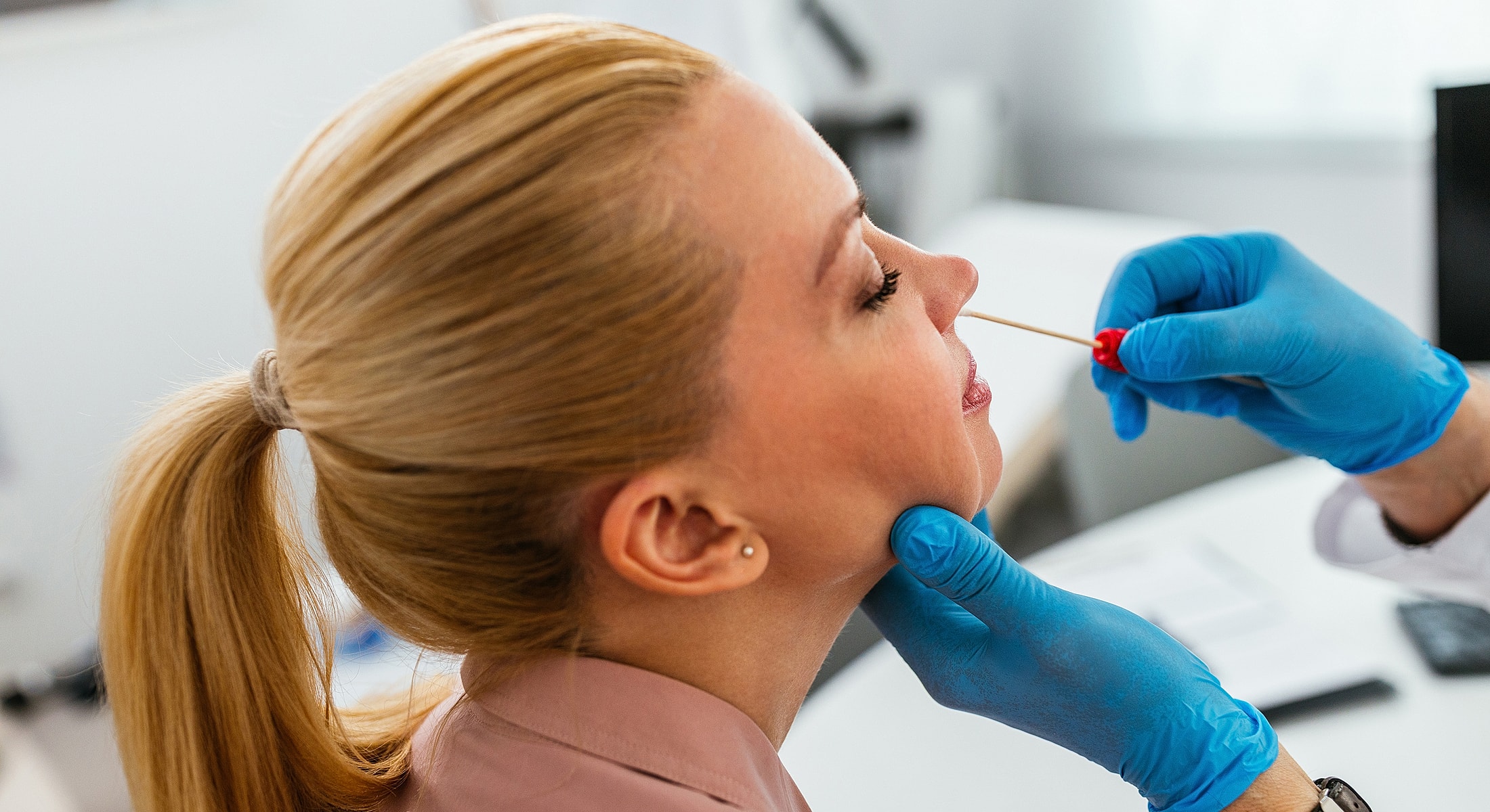 Medical professional administering nasal swab test.