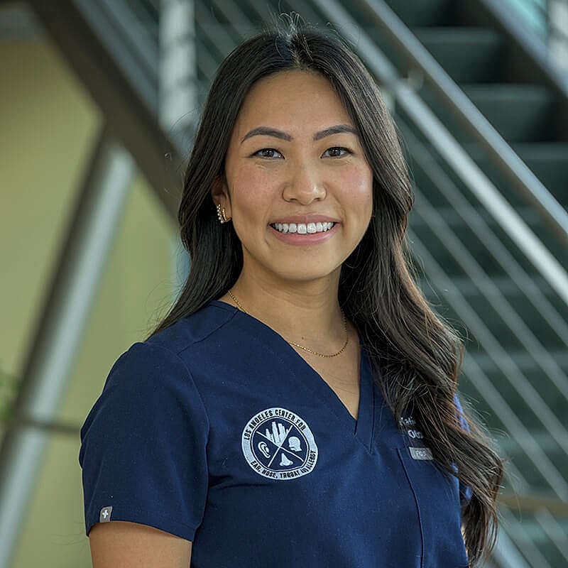 Smiling healthcare professional in medical attire.