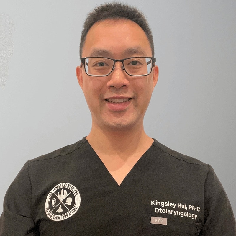 Person in medical attire smiling for photo.