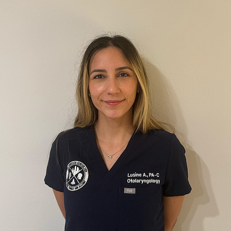 Female healthcare professional in scrubs, smiling.