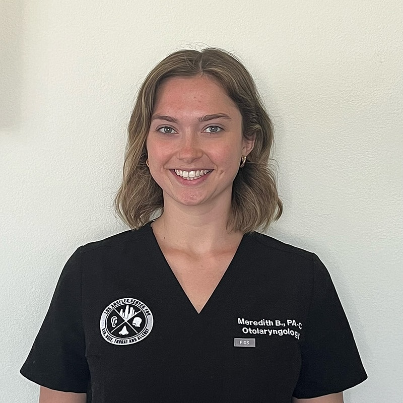Healthcare professional smiling in black scrubs.