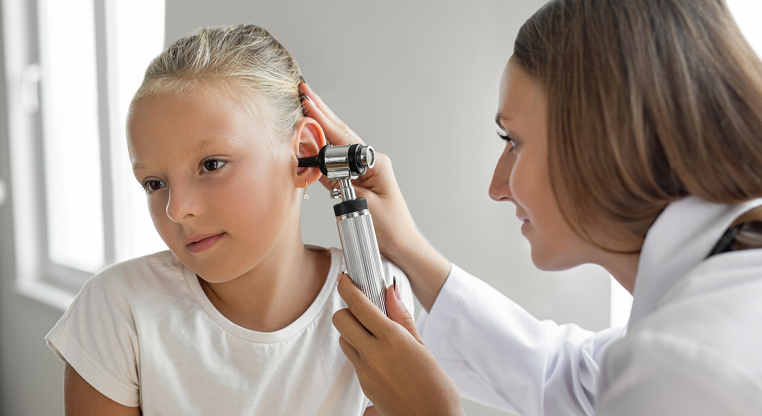 Child receiving an ear examination from doctor.