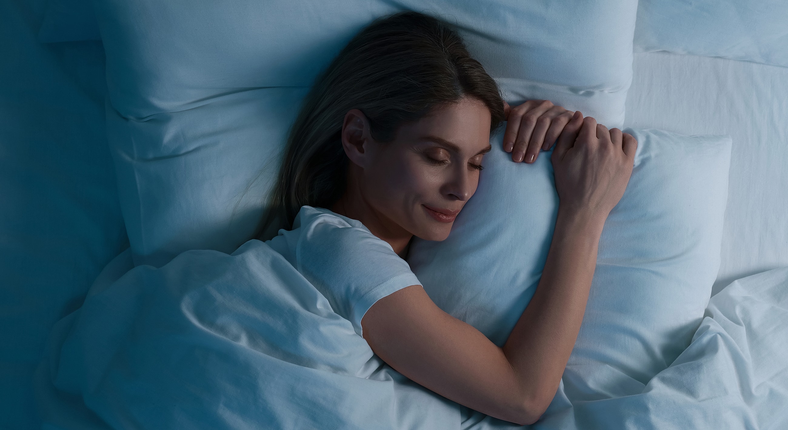 Woman peacefully sleeping with a pillow.
