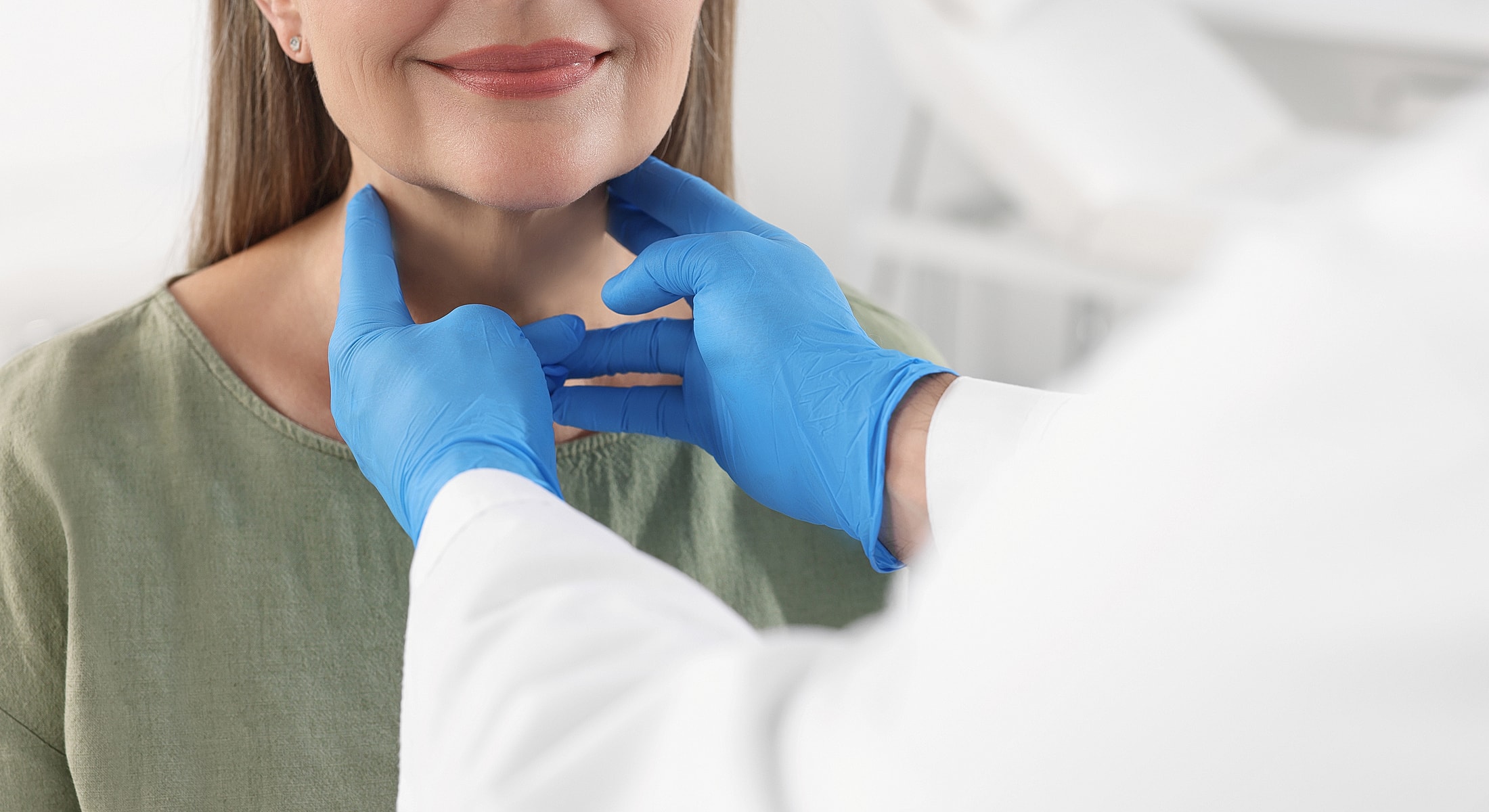 Healthcare professional examining patient's neck and jaw.